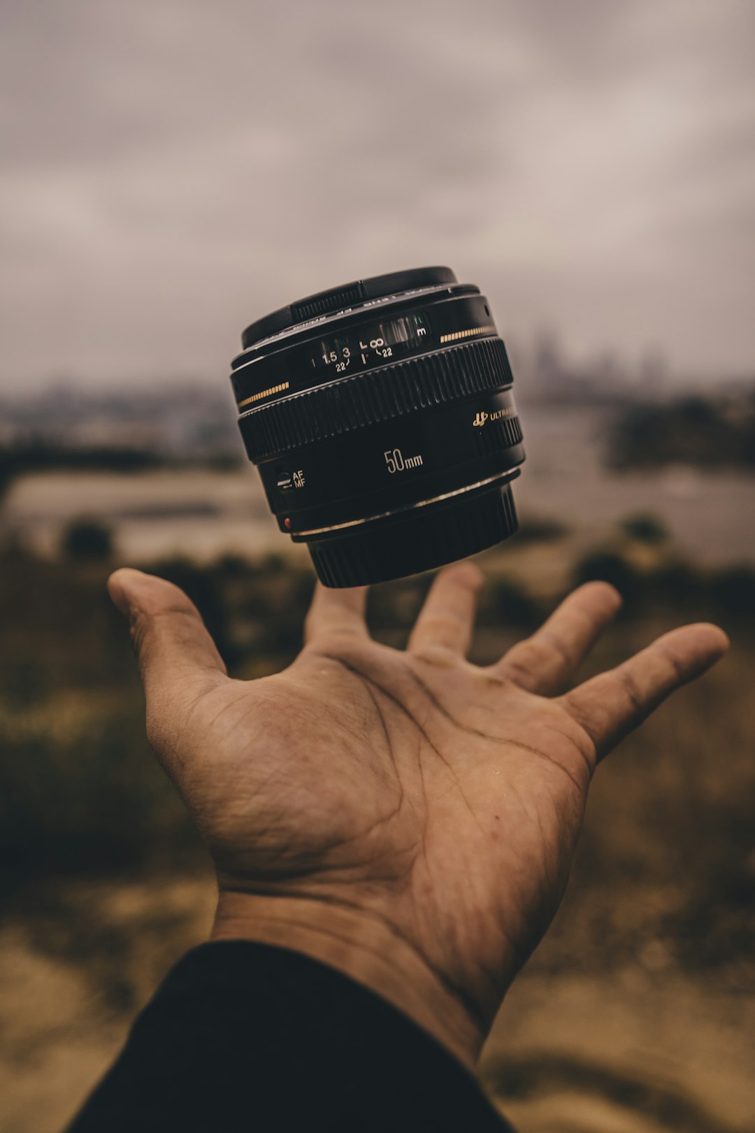 person-holding-camera-lens-ubqvjh69ooq