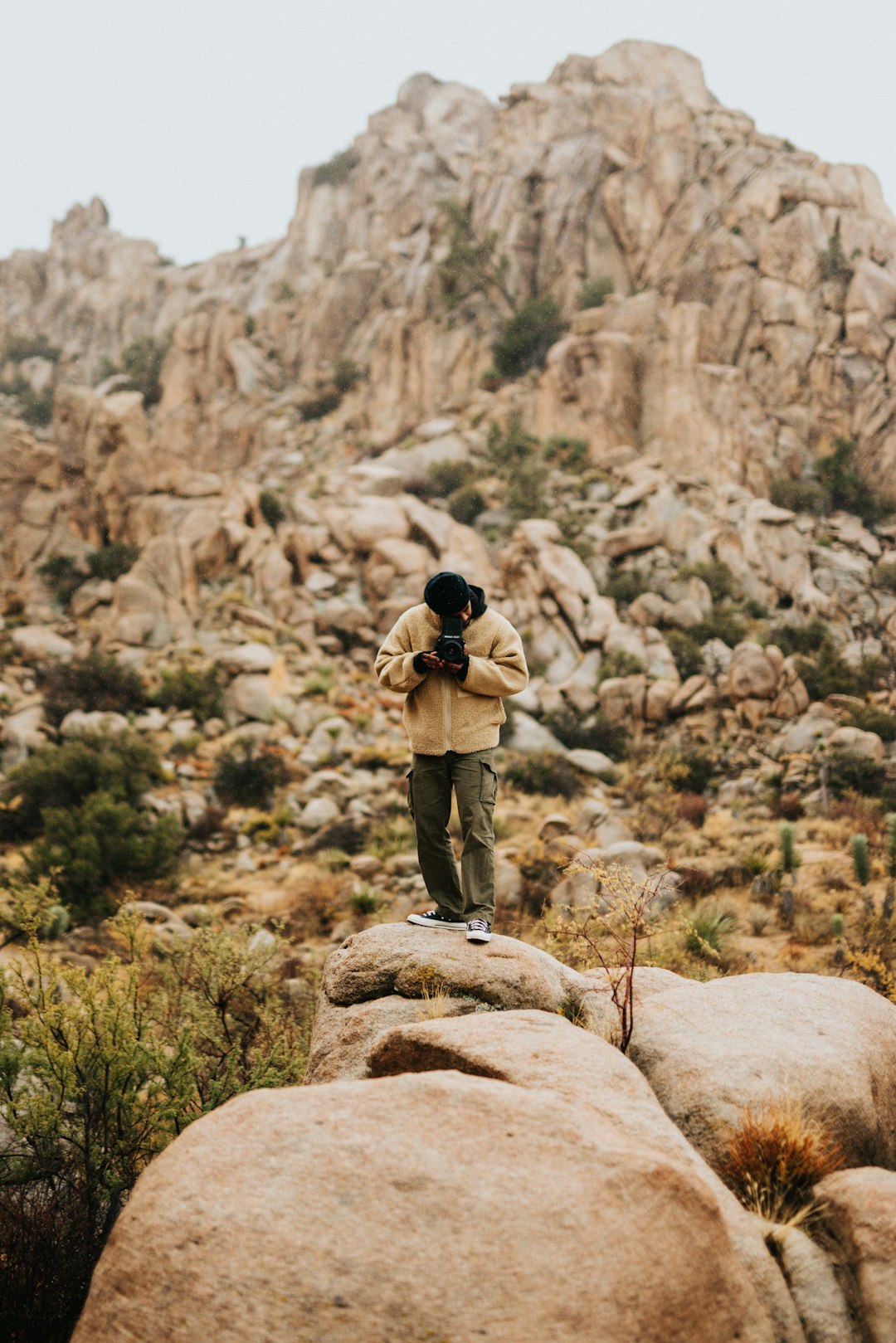 man-in-black-jacket-and-brown-pants-standing-on-brown-rock-during-daytime-spvs4s7zsak